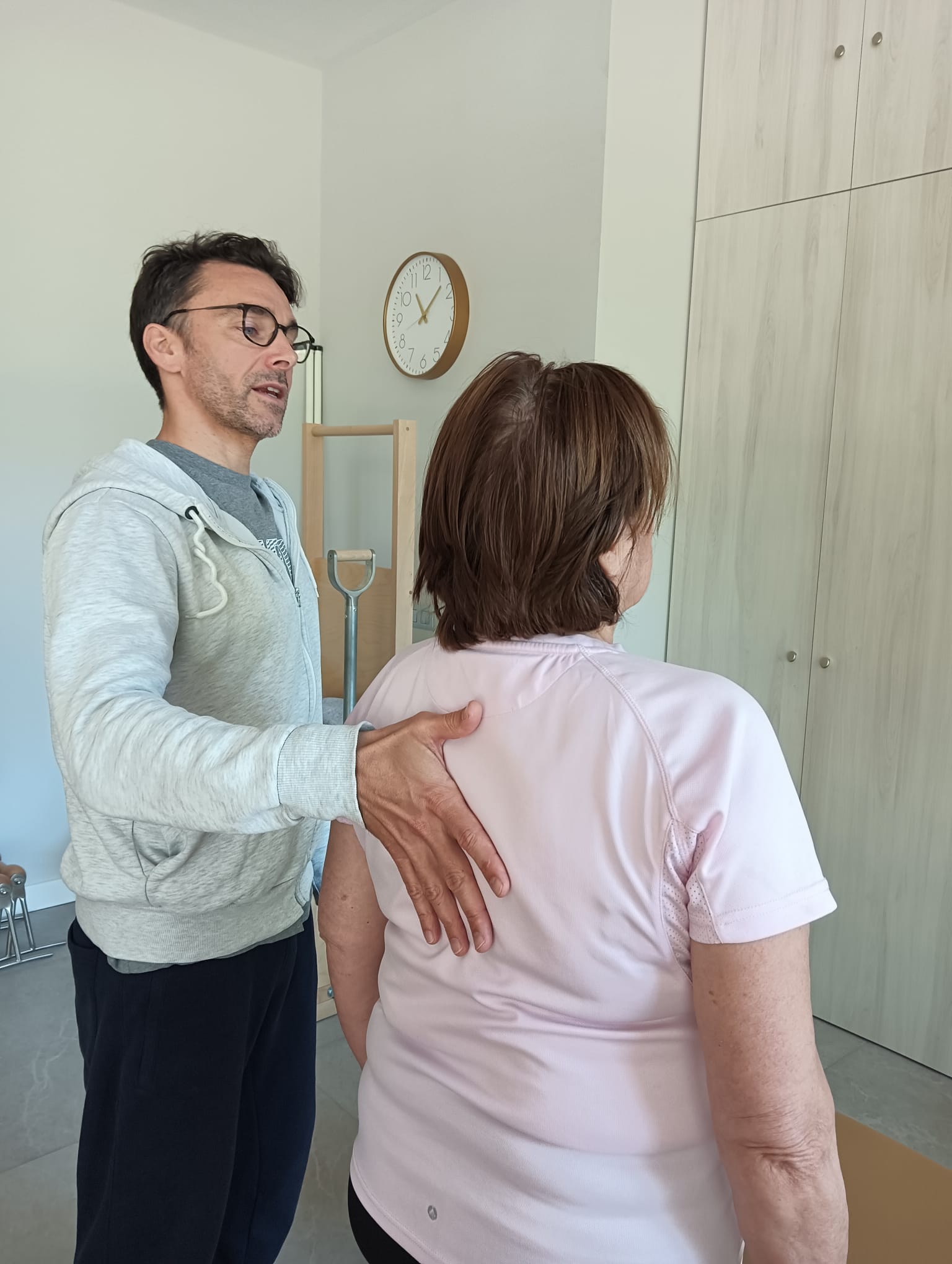 Instructor de True Pilates recolocando la postura de una alumna